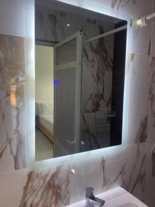 a bathroom mirror with a sink and a shower at Logement entier et indépendant D in Rabat