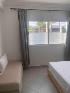 a bedroom with a bed and a large window at Logement entier et indépendant D in Rabat