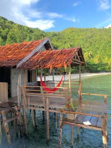 eine Hütte auf dem Wasser mit einem roten Seil in der Unterkunft Firdas Bungalows in Waisai
