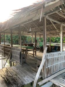 a wooden pavilion with wooden benches and tables at Firdas Bungalows in Waisai