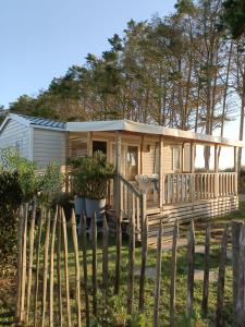 a tiny house with a porch and a fence at Mobilhomes Quiberon Camping Conguel - Bord de Mer in Quiberon
