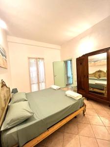 a bedroom with a large bed and a mirror at Casa Rosa in Finale Ligure