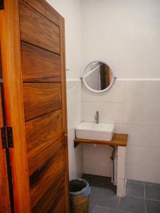 a bathroom with a sink and a wooden door at Meexok river view in Nongkhiaw