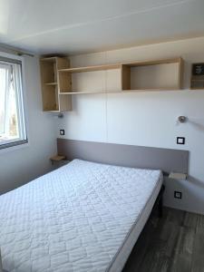 um quarto com uma cama branca num quarto em Mobilhomes Quiberon Camping Conguel - Bord de Mer em Quiberon