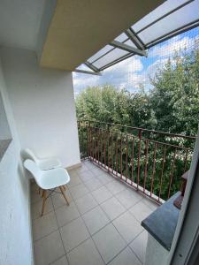 a white chair sitting on a balcony with a railing at Przy Moście in Rzeszów +27 photos