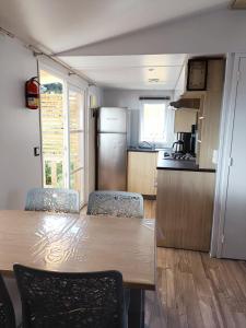 uma cozinha com uma mesa e cadeiras numa cozinha em Mobilhomes Quiberon Camping Conguel - Bord de Mer em Quiberon