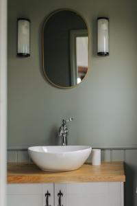 La salle de bains est pourvue d'un lavabo blanc et d'un miroir. dans l'établissement Barley Shepherd Hut - Snettisham Meadows, à King's Lynn