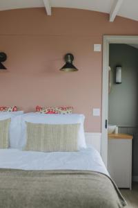 キングズ・リンにあるBarley Shepherd Hut - Snettisham Meadowsのベッドルーム1室(白いシーツと枕のベッド1台付)