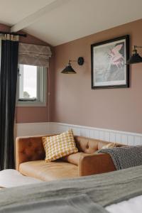 een woonkamer met een bank en een raam bij Barley Shepherd Hut - Snettisham Meadows in Kings Lynn