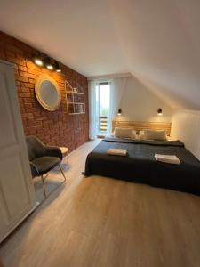 a bedroom with a bed and a brick wall at Polana in Lipowiec