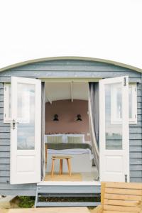 Cette petite maison comprend un lit et une table. dans l'établissement Barley Shepherd Hut - Snettisham Meadows, à King's Lynn