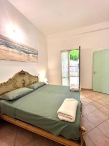um quarto com uma grande cama verde e uma janela em Casa Rosa em Finale Ligure