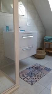 een badkamer met een wit dressoir en een trap bij Maison récente à 300 m de la mer in Carantec