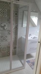 een glazen douche in een badkamer met een wastafel bij Maison récente à 300 m de la mer in Carantec