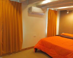 a bedroom with an orange bed and a window at MAJO Rest&Dream I in Goya