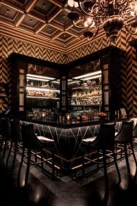 um restaurante com um bar com cadeiras num quarto em Schlosshotel Berlin by Patrick Hellmann em Berlim