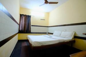 a bedroom with a bed with a ceiling fan at Bava Inn in Chennai