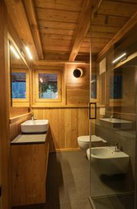 La salle de bains est pourvue de 2 lavabos et de 2 toilettes. dans l'établissement Maroc Mountain Chalet, à Madonna di Campiglio