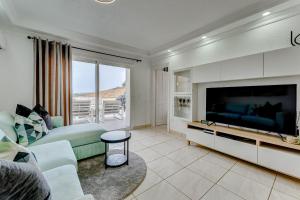 a living room with a large television and a couch at Ramada Costa Adeje Apartment in Adeje