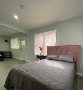 1 dormitorio con 1 cama grande y cabecero rosa en The Oasis, en Sanford