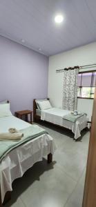 a bedroom with two beds and a window at Casa Ypê - Vila de São Jorge in Sao Jorge