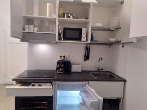 una pequeña cocina con fregadero y microondas en Studio-Apartment 22 - 3R1, en Essen