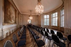 an empty room with chairs and a chandelier at Schlosshotel Berlin by Patrick Hellmann in Berlin