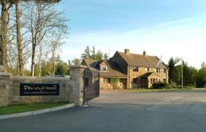 a house with a sign in front of a driveway at Woodland Hot Tub Retreat in Swarland