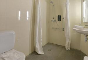 a bathroom with a shower and a toilet and a sink at B&B HOTEL Le Mans Nord 1 in Saint-Saturnin
