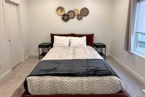 a bedroom with a bed with two tables and a clock on the wall at Village Green Getaway in Park City