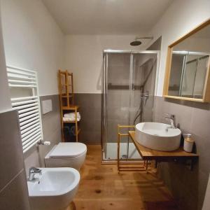 ein Badezimmer mit zwei Waschbecken, einer Dusche und einem WC in der Unterkunft Rolli House in Genua