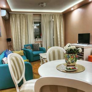 ein Wohnzimmer mit einem Tisch und Stühlen in der Unterkunft Apartman Diana in Sremska Mitrovica