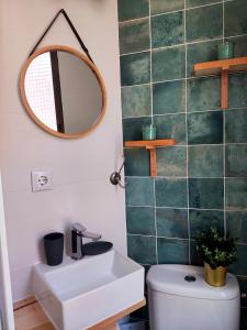 a bathroom with a sink and a mirror and a toilet at Apartamento con encanto en el puerto de Bermeo in Bermeo