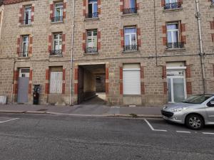 a car parked in front of a brick building at Suite Évasion Céleste à Saint-Étienne in Saint-Étienne