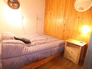 ein kleines Schlafzimmer mit einem Bett und einem Nachttisch in der Unterkunft Appartement Huez, 2 pièces, 4 personnes - FR-1-405-140 in L'Alpe-d'Huez