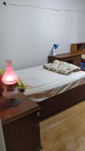 a bedroom with a bed with a pink lamp on a table at Ismailia - Elnouras compound in Ismailia