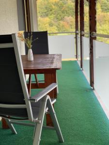 una silla sentada junto a una mesa con un jarrón en Ferienwohnung Fam.Werner, en Wasungen