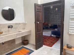 une salle de bains avec une porte ouverte sur une chambre. dans l'établissement Maison typique de la médina, à Tunis