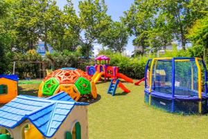 a playground with colorful play equipment in a park at Hotel Duca di Kent in Cesenatico
