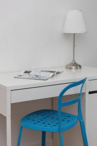 a blue chair sitting at a desk with a lamp at Siedmiogrodzka Air-conditioned Apartment with Balcony Wola by Renters in Warsaw