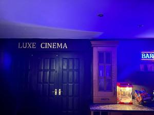 a blue room with two doors and a sign at 4 Bedroom House, Heathrow Airport, Luxe Inn in Colnbrook