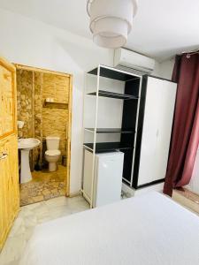 um quarto com uma casa de banho com um WC e um frigorífico em Joy Beach B&B em Torremolinos