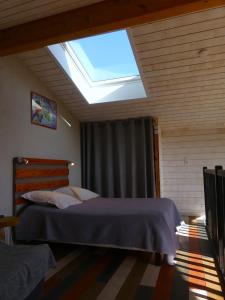 1 dormitorio con 1 cama grande y tragaluz en Gites Arnoult en Damiatte