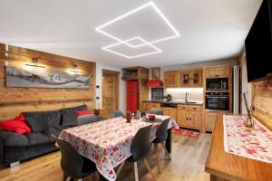 a kitchen and living room with a table and a couch at Jorasses La Maison de Courma in Courmayeur
