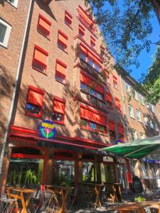 Un edificio con mesas y sillas delante. en Victoria Boardinghouse, en Düsseldorf