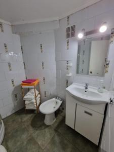 a bathroom with a sink and a toilet and a mirror at Vista al Mar Departamento - Edificio Acapulco in Viña del Mar