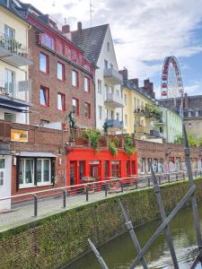 a group of buildings next to a river with a ferris wheel at Victoria Boardinghouse in Düsseldorf