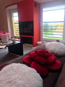 a living room with red and white pillows on a couch at Rožu romantika in Cēsis