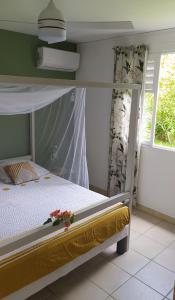 a bedroom with a bunk bed with a flower on it at Les poinsettias in Les Trois-Îlets