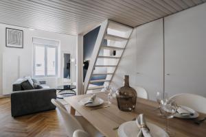 a dining room and living room with a table and a staircase at CLASSIC JOURNEY duplex centre ville Cholet in Cholet